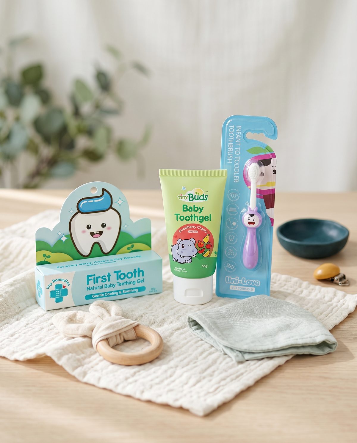 Baby teething gel, toothgel and training toothbrush on a muslin cloth